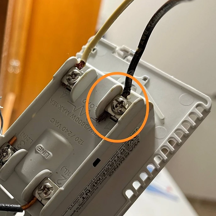 A loose or poorly seated wire under a terminal screw can cause arcing — tiny electrical sparks that generate heat and damage insulation over time. Always have a licensed electrician inspect connections like this before they become a fire hazard.