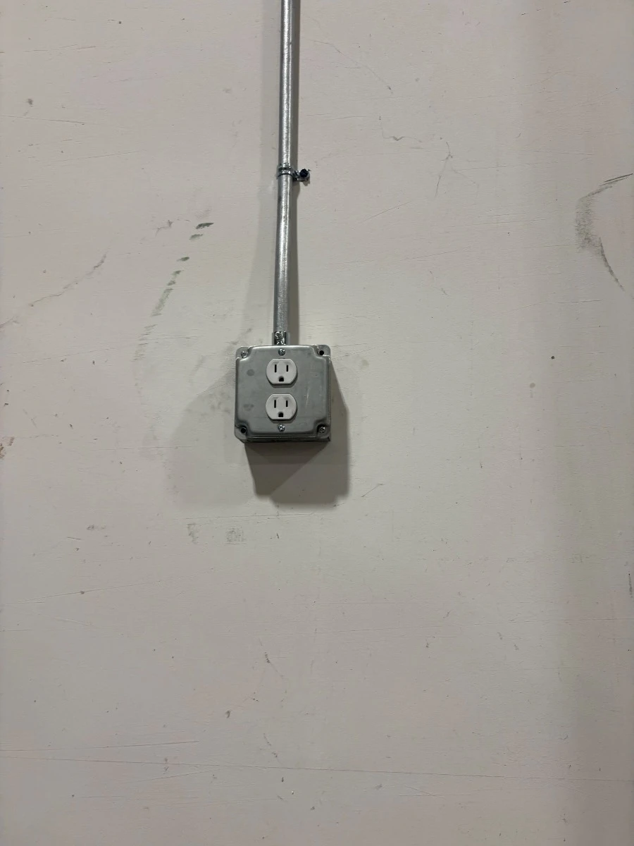 Newly installed wall receptacle with EMT conduit in a Brooklyn Park, MN home.