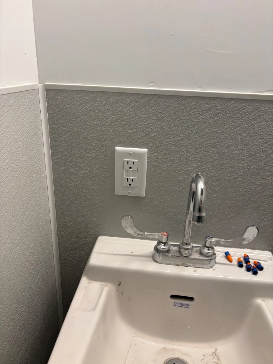 Image of New GFCI receptacle installed in a remodeled commercial bathroom