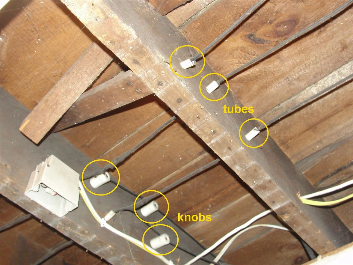 Knob-and-tube wiring in the attic of an older Minnesota home. This outdated system, common in houses built before the 1950s, uses ceramic knobs and tubes to support and insulate wires. 