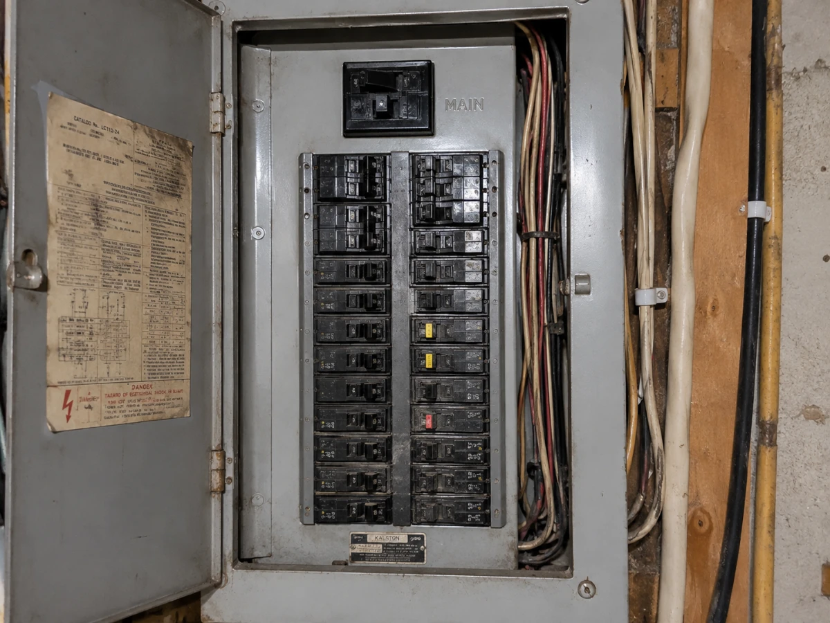 Image of an outdated electrical panel with old circuit breakers 